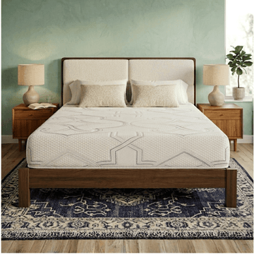 Bedroom with a Mattress Makers mattress on a wooden bed, nightstands, and lamps against a green wall.