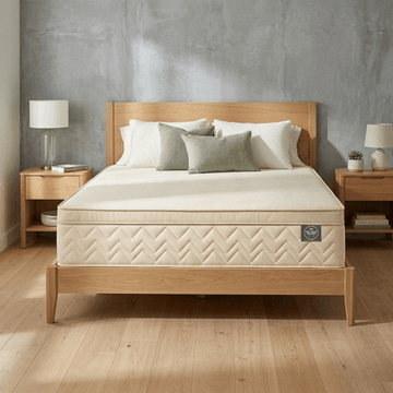 Beige Mattress Makers mattress on a wooden bed frame in a bedroom setting with shelves and decor.