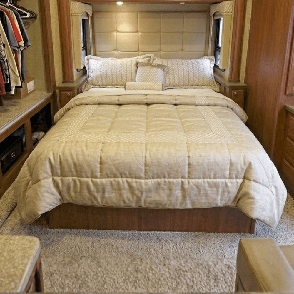 Bedroom with a bed covered in beige bedding, wooden furniture, and a closet.